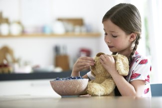 girl feeding a teddy