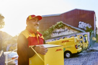 DHL courier deliuvering a parecel in early morning sun