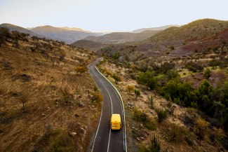 droneshot of a DHL van driving on a desert road
